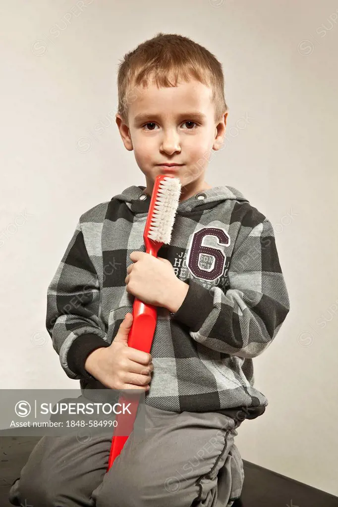 Boy holding a giant toothbrush