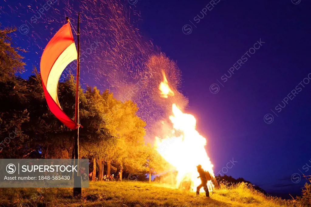 Fire on Kleiner Penegal mountain above Kaltern, Sacred Heart-Fire, with the flag of Tyrol, province of Bolzano-Bozen, Italy, Europe