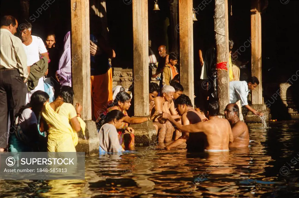 Pilgrims bathing in the source of the holy river Godavari to wash away sins, Trmbak, Maharashtra, India, Asia