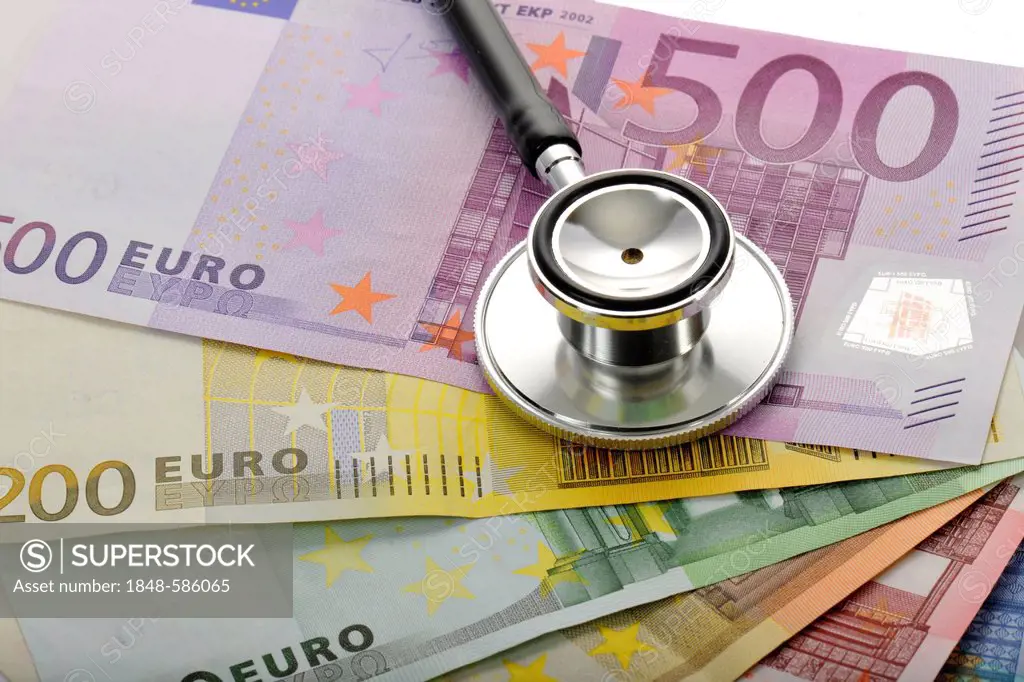 Stethoscope on a fan of euro banknotes, symbolic image of the sick euro, health care cost explosion, medical expenses