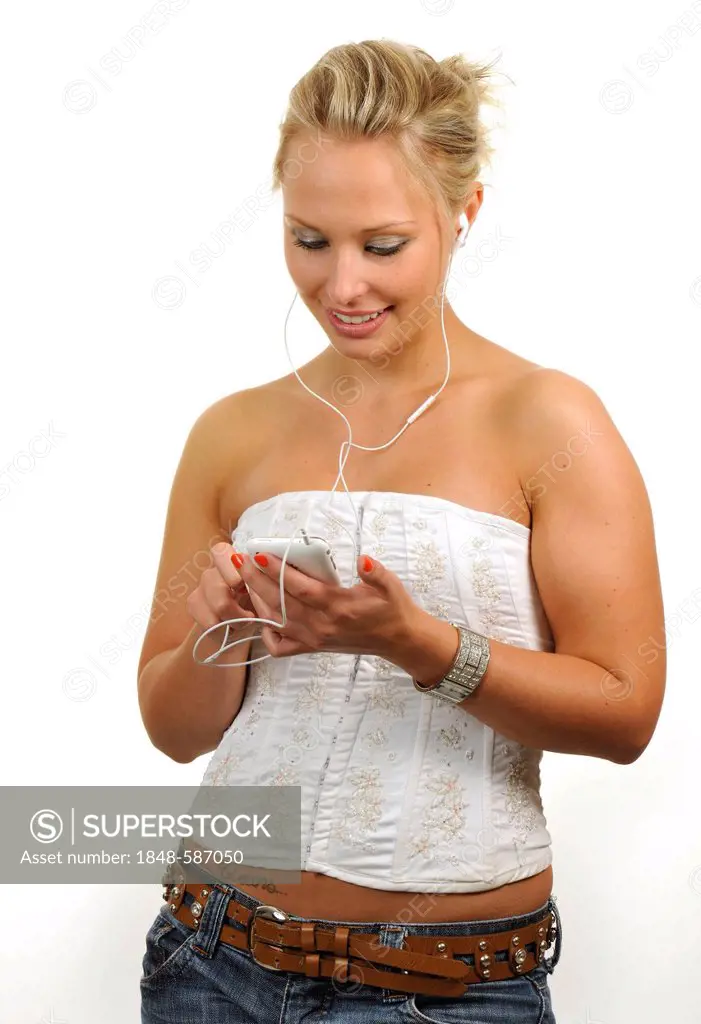 Young woman using a white Apple iPhone, listening to music with earphones