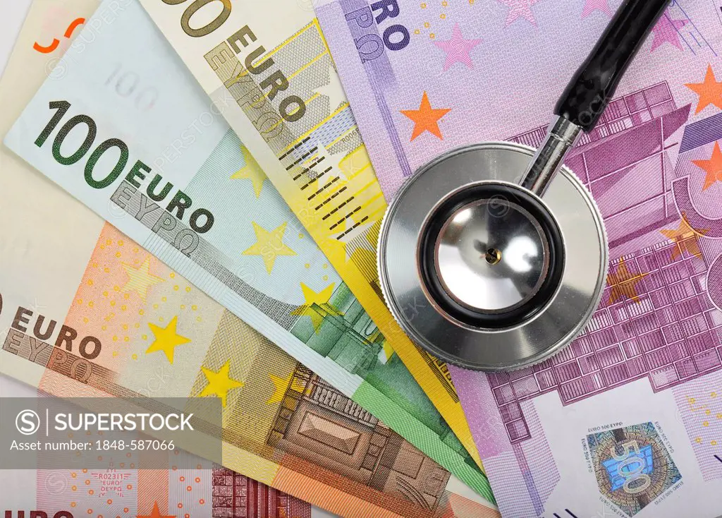 Stethoscope on a fan of euro banknotes, symbolic image of the sick euro, health care cost explosion, medical expenses
