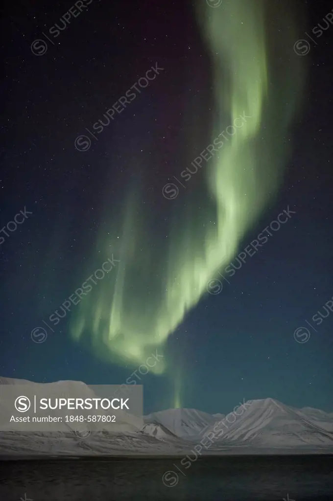 Green Northern Lights, Aurora Borealis, over the mountains of Longyearbyen lit by the crescent moon, Spitsbergen, Svalbard, Norway, Europe