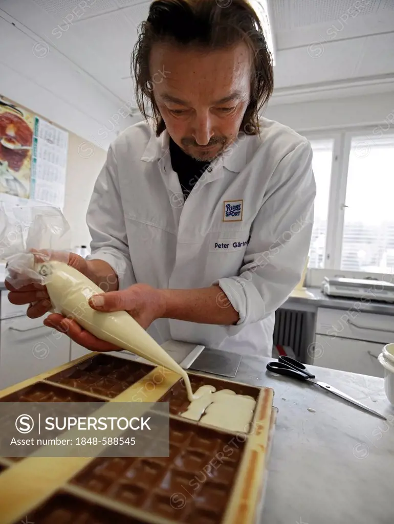 Developer for new products filling liquid cream into chocolate moulds in the development department of the Ritter Sport chocolate factory of Alfred Ri...