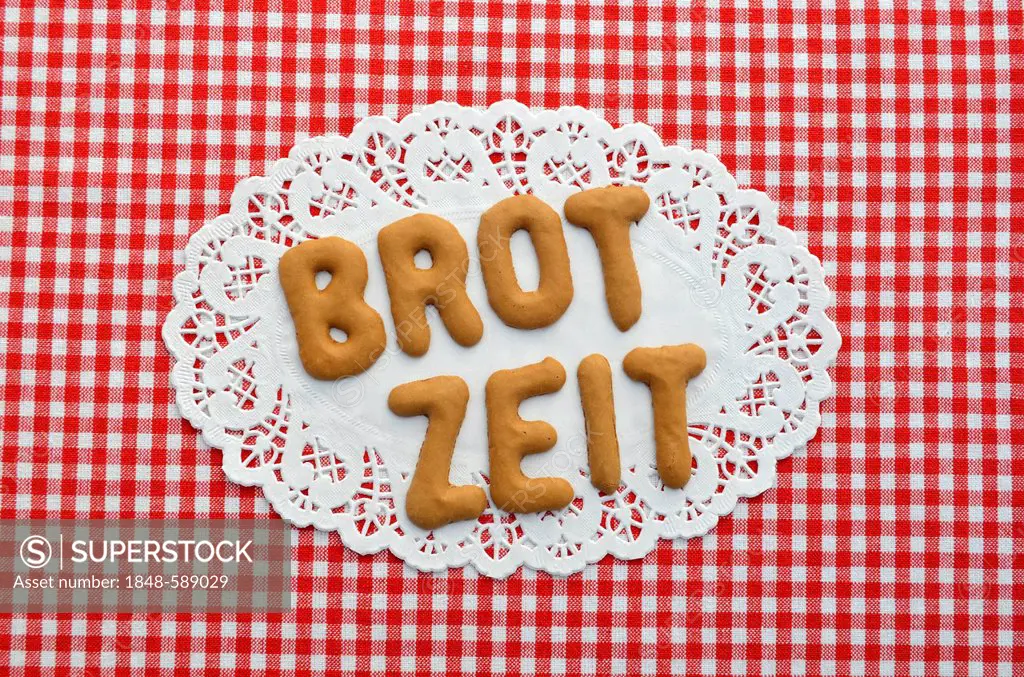 Brotzeit or snack written in alphabet biscuits on paper doily