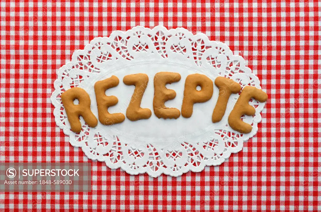 Rezept or recipe written in alphabet biscuits on paper doily