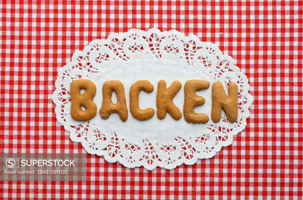 Backen or backing written in alphabet biscuits on paper doily