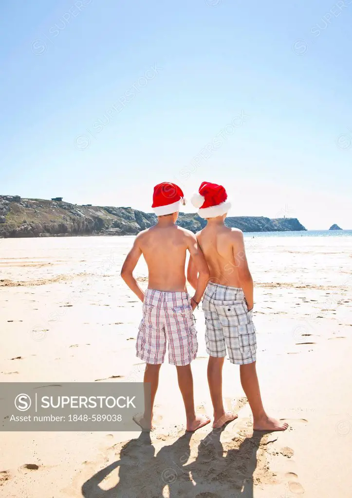 Two teenagers with Santa hat on the beach, Camaret-sur-Mer, Finistere, Brittany, France, Europe