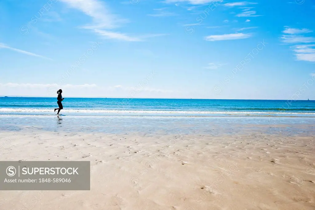 Woman jogging on the beach, Camaret-sur-Mer, Finistere, Brittany, France, Europe