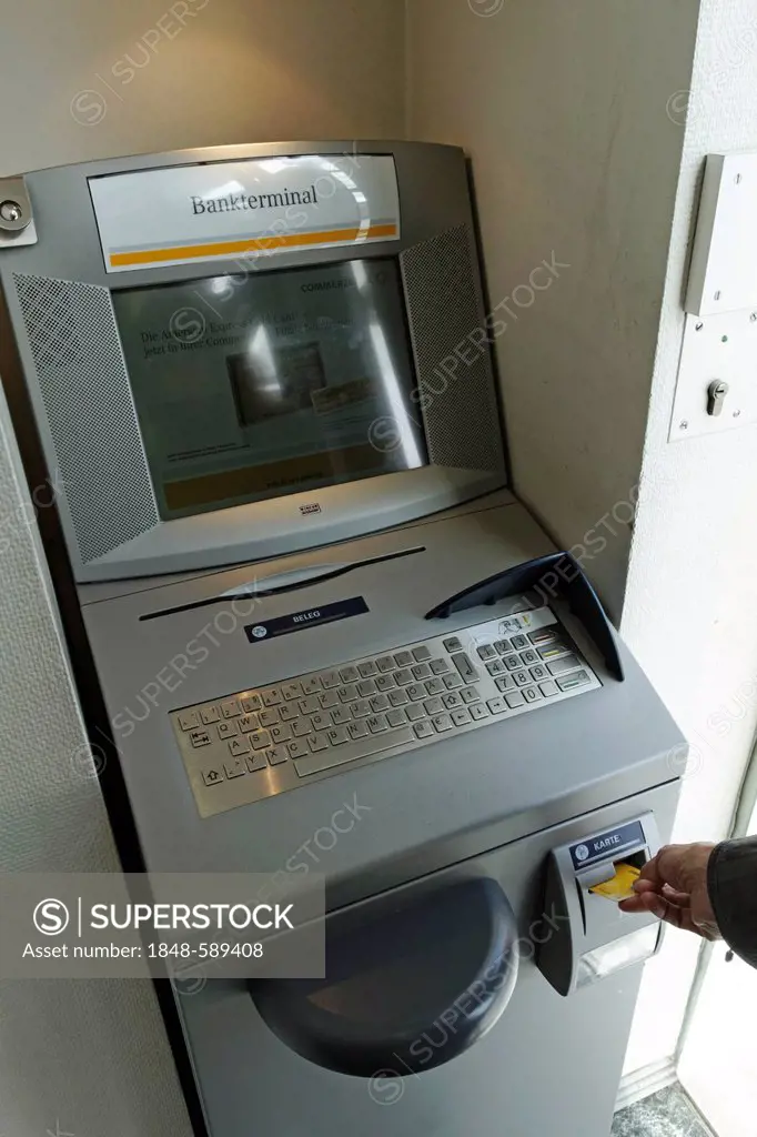 Placing a card into a German bank terminal that issues statements, Rosenheim, Upper Bavaria, Germany, Europe
