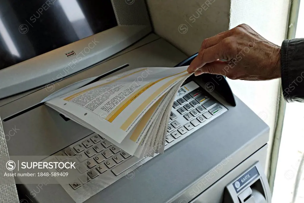 Removing statements from a German bank terminal that issues statements, Rosenheim, Upper Bavaria, Germany, Europe