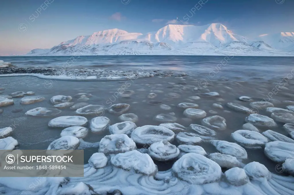 Sea ice forming on the Advent Fjord, Mt Hjorthfellet at back, Longyearbyen, Spitsbergen, Svalbard, Norway, Europe,