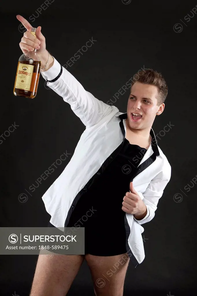 Young man holding a bottle of whiskey
