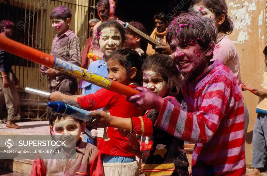 Kids spraying coloured water at the Holi festival, Vrindaban, Uttar Pradesh, India, Asia