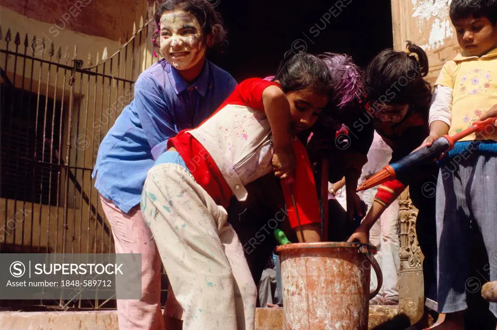 Kids playing with coloured water at the Holi festival, Vrindaban, Uttar Pradesh, India, Asia
