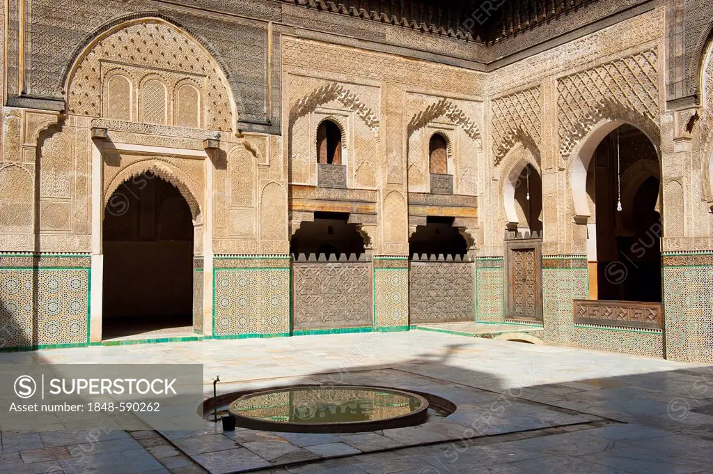 Courtyard of the Koran school, Madrasa Bou Inania, with wash fountains, walls and arches with carved cedar wood, stucco ornaments and tiled mosaics, F...