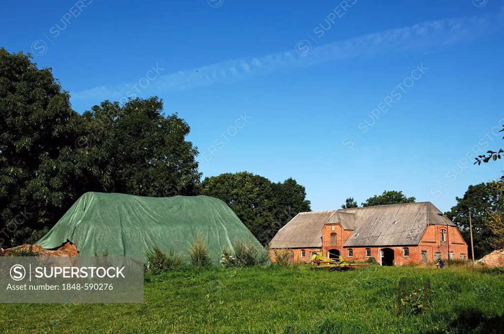 Historic horse stable built in 1921, covered bales of straw on the left, Gut Othenstorf estate, Othenstorf, Mecklenburg-Western Pomerania, Germany, Eu...