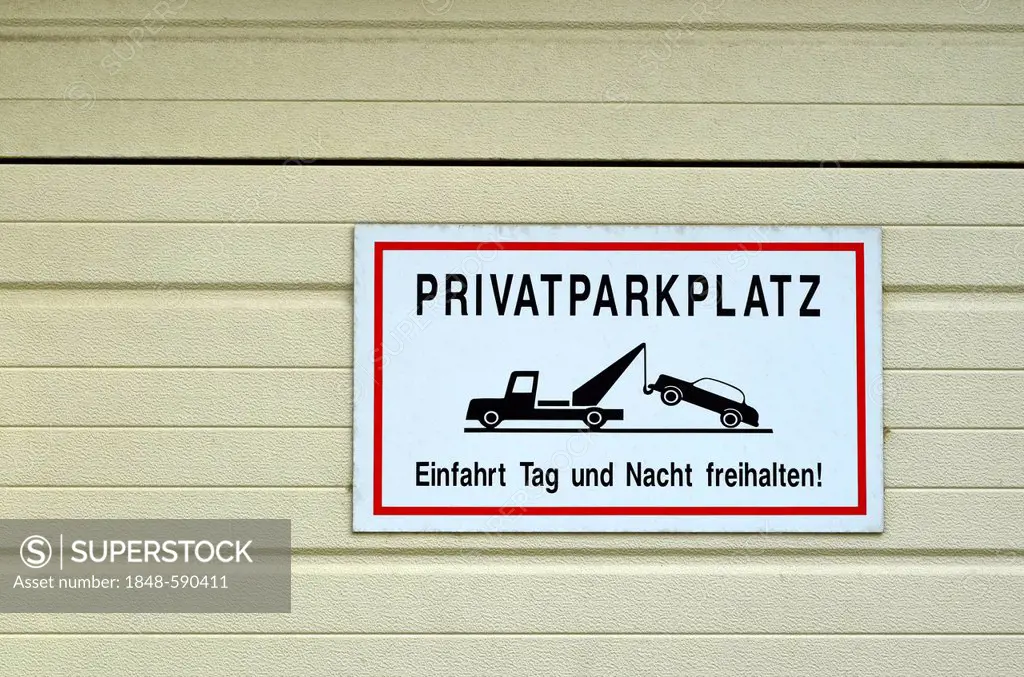 Privatparkplatz, German for private car park, sign on a garage door, Duesseldorf, North Rhine-Westphalia, Germany, Europe