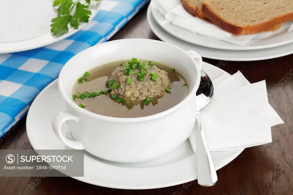 Liver dumplings in beef broth, sprinkled with chives, and bread