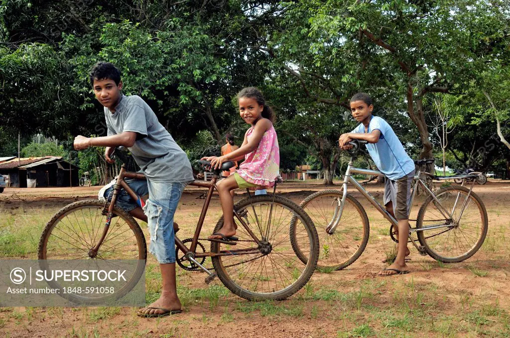 Three children on bicycles, Acampamento 12 de Otubro landless camp, Movimento dos Trabalhadores Rurais sem Terra, a Brazilian landless movement, MST, ...
