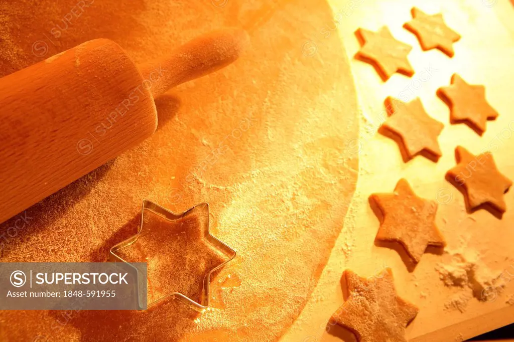 Christmas cookies, cookie dough and a star-shaped cookie cutter with a rolling pin