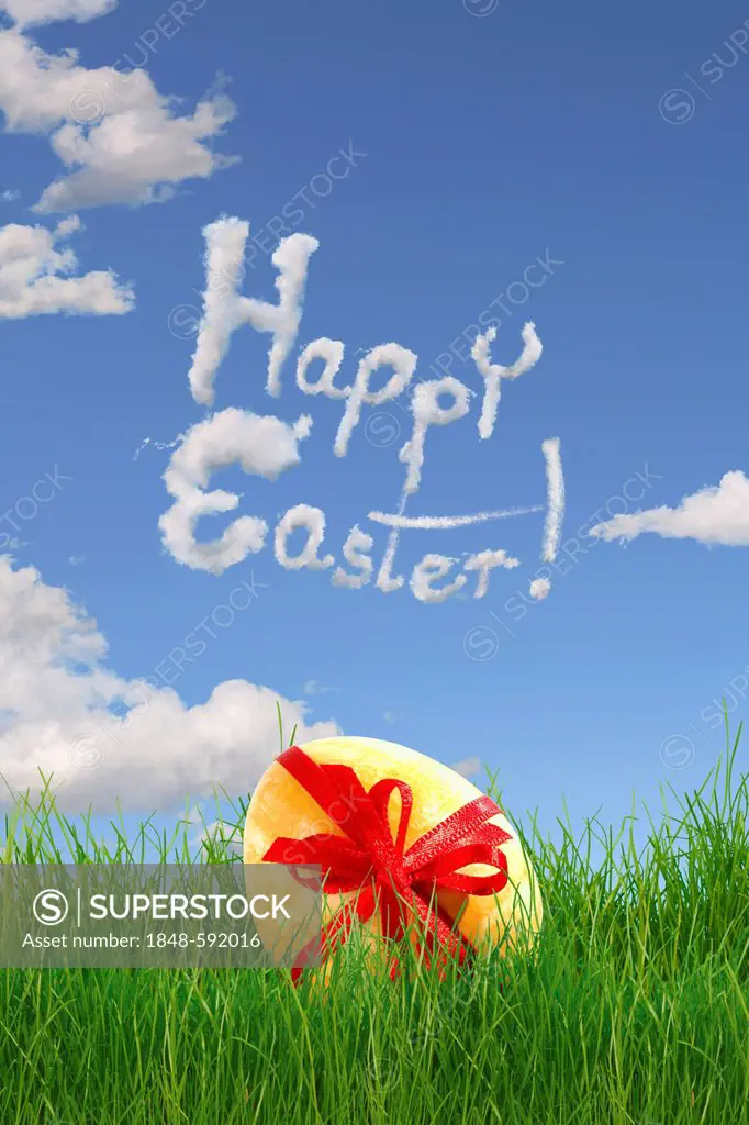 Easter egg with a bow lying in the grass, lettering Happy Easter
