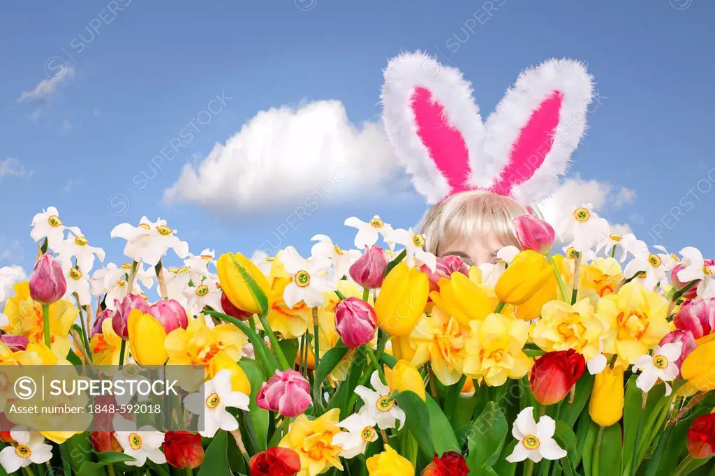 Woman wearing bunny ears hiding in a flower field