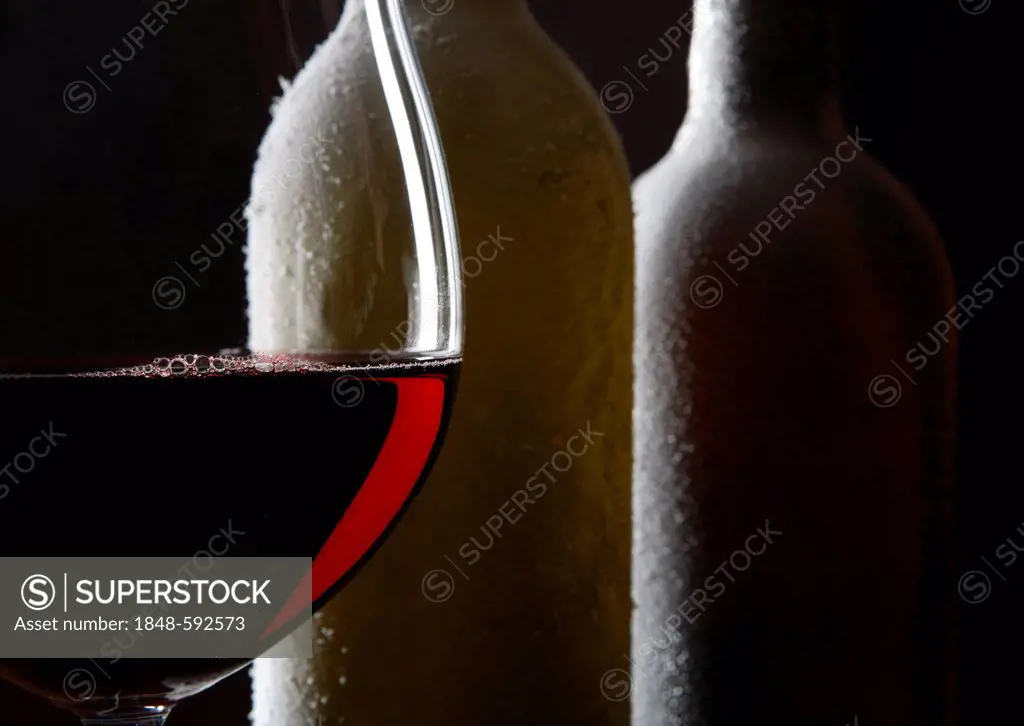 Red wine glass, wine bottles