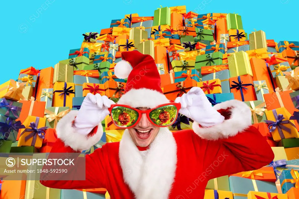 Santa Claus wearing oversized glasses, standing in front of a pile of gifts