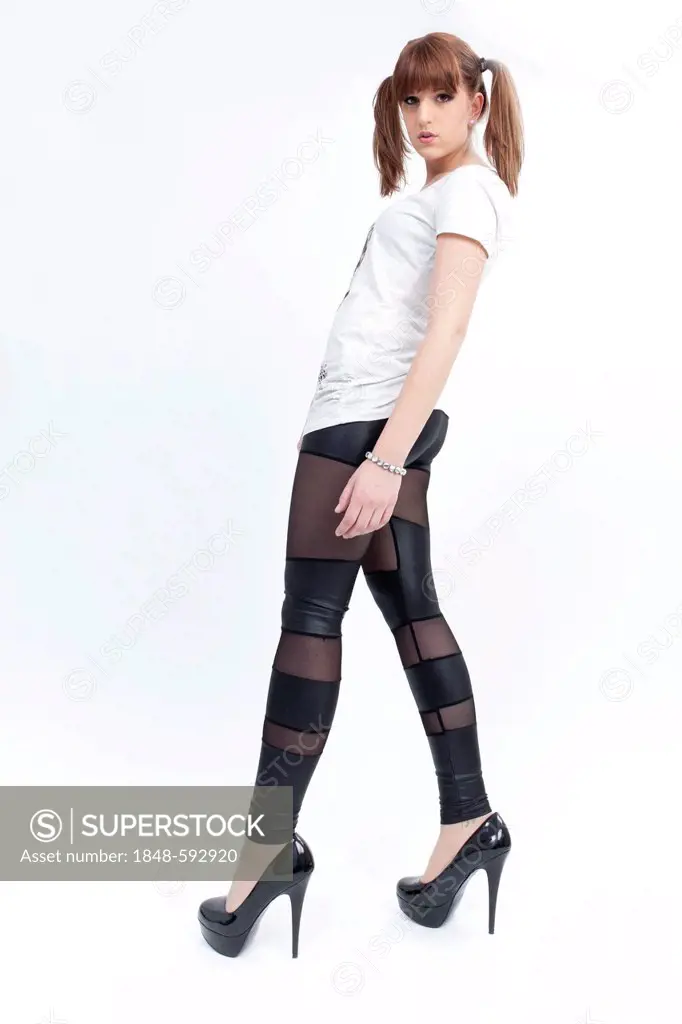 Young woman with pigtails, white shirt, semi-transparent leggings and high heels