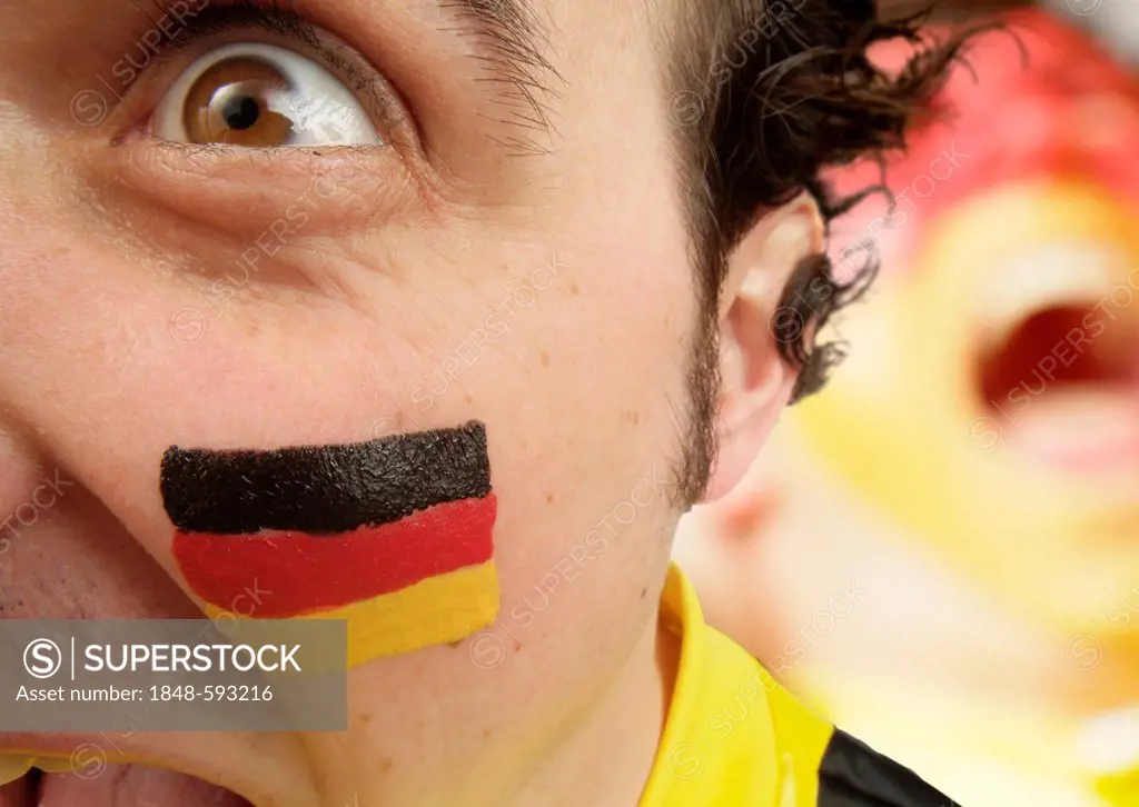 Football fan with his face painted in the national colours of Germany