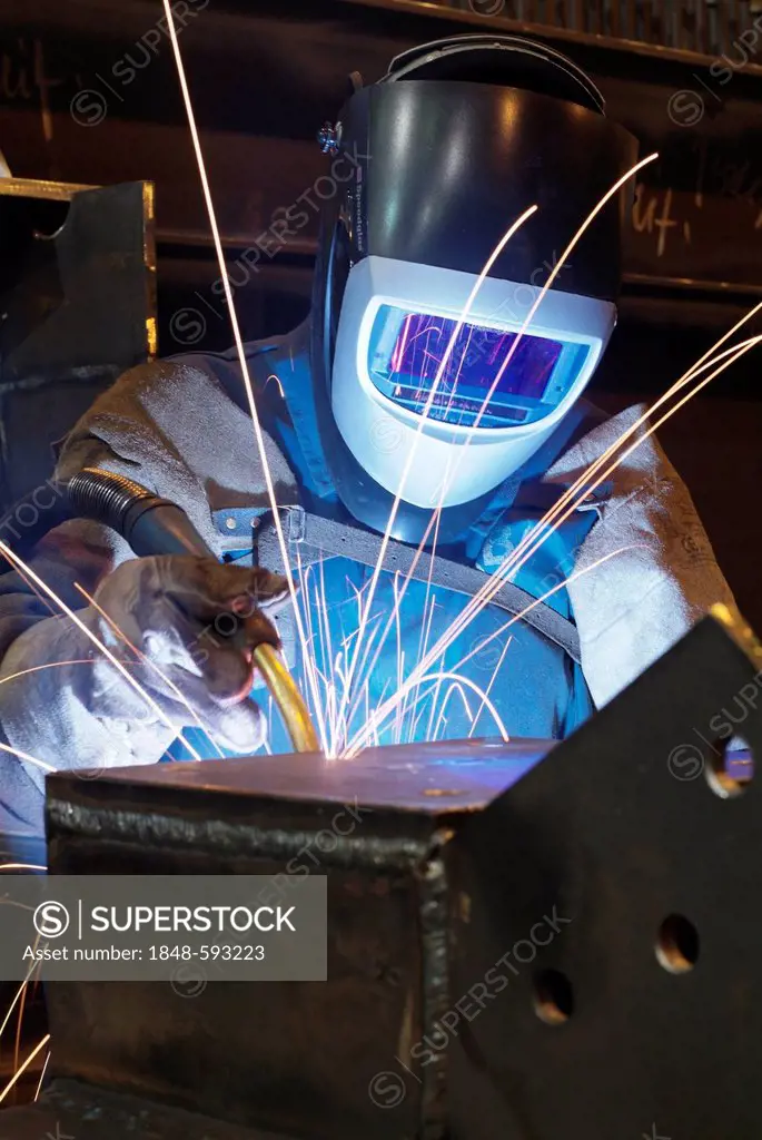 Welder wearing protective clothing in a steel mill