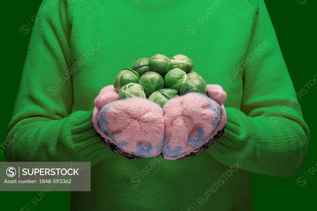 Hands wearing knitted gloves holding brussels sprouts