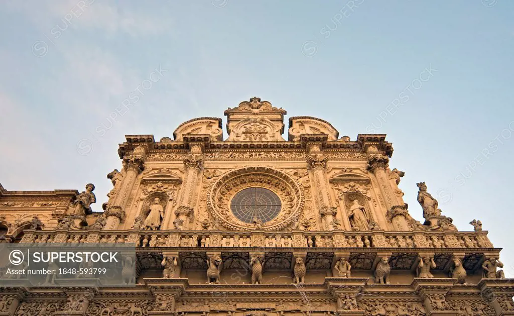 Richly decorated facade with rose window or Catherine window of Baroque Basilica di Santa Croce, Church of Holy Cross, completed in 1695, Lecce, Apuli...