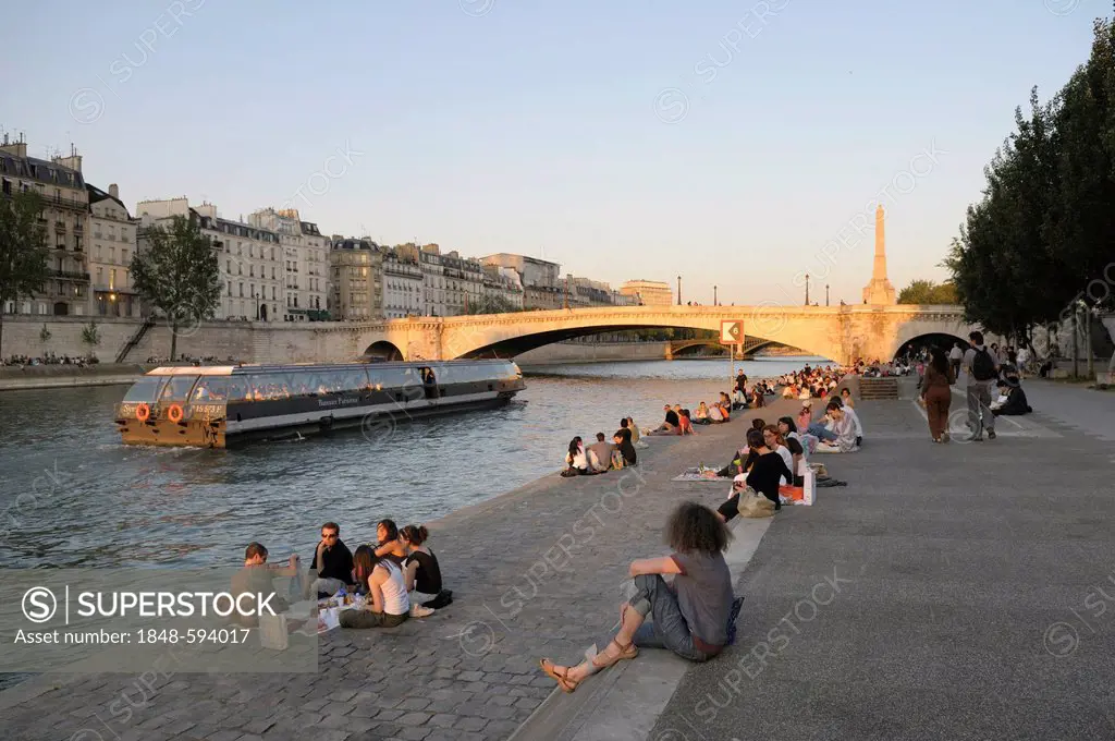 People on the banks of Seine River, Pont de la Tournelle bridge, Paris, France, Europe