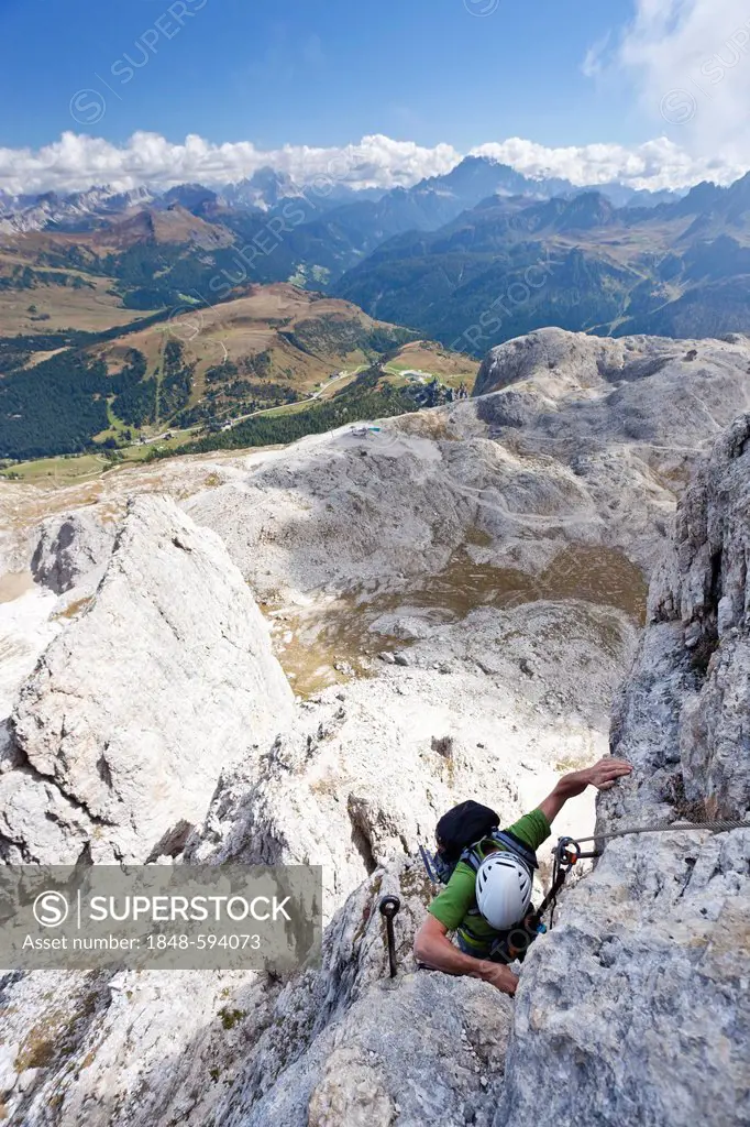 Mountain climber ascending the Boeseekofel climbing route, in front of the Fanes Group mountains, Dolomites, Alto Adige, Italy, Europe