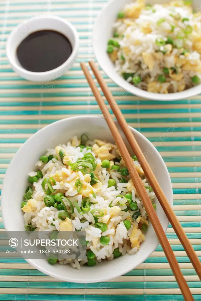 Fried egg rice in a bowl, soy sauce and chopsticks