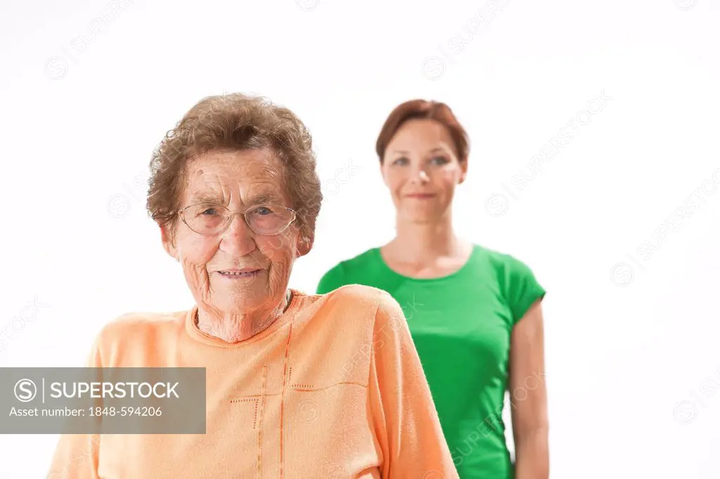 Smiling young woman standing behind an older woman