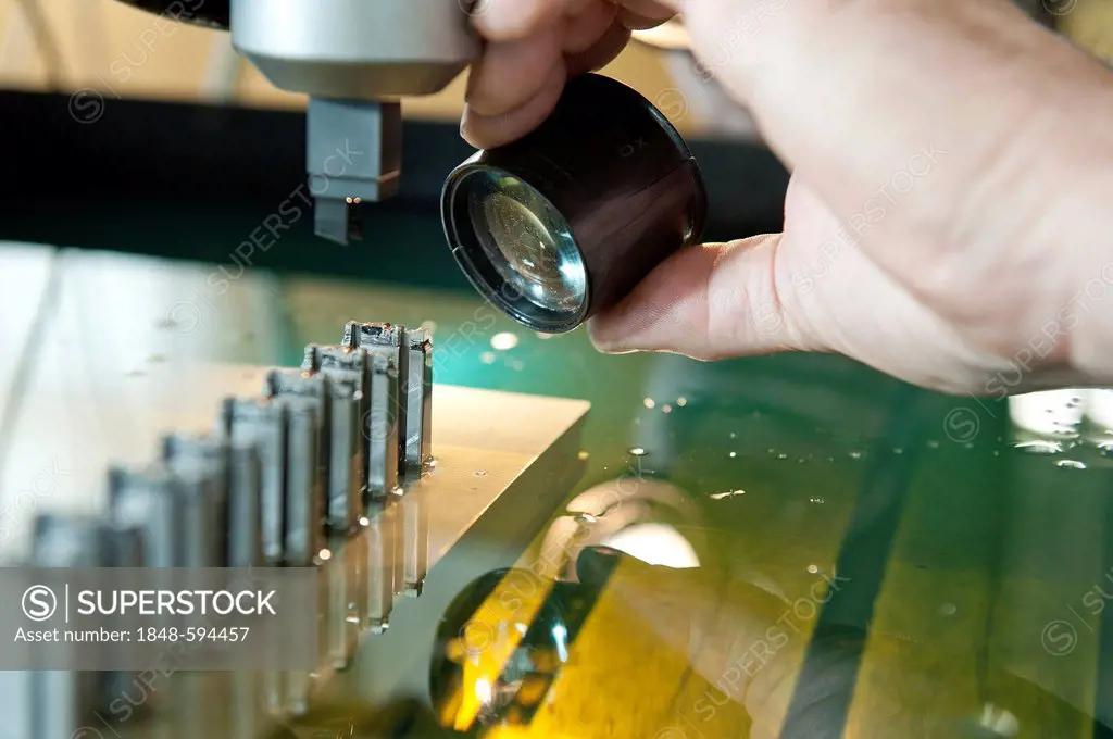 Electric discharge machine, eroding small pieces, work being checked with a loupe, design and construction for plastic injection moulding tools