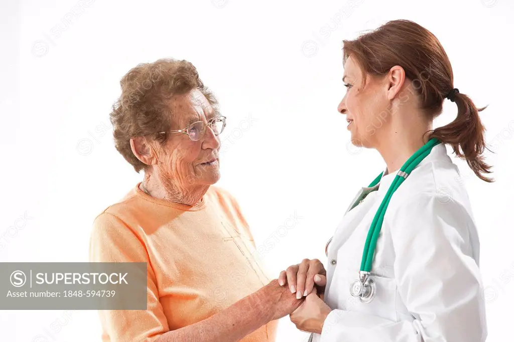 Smiling doctor holding an elderly woman's hand