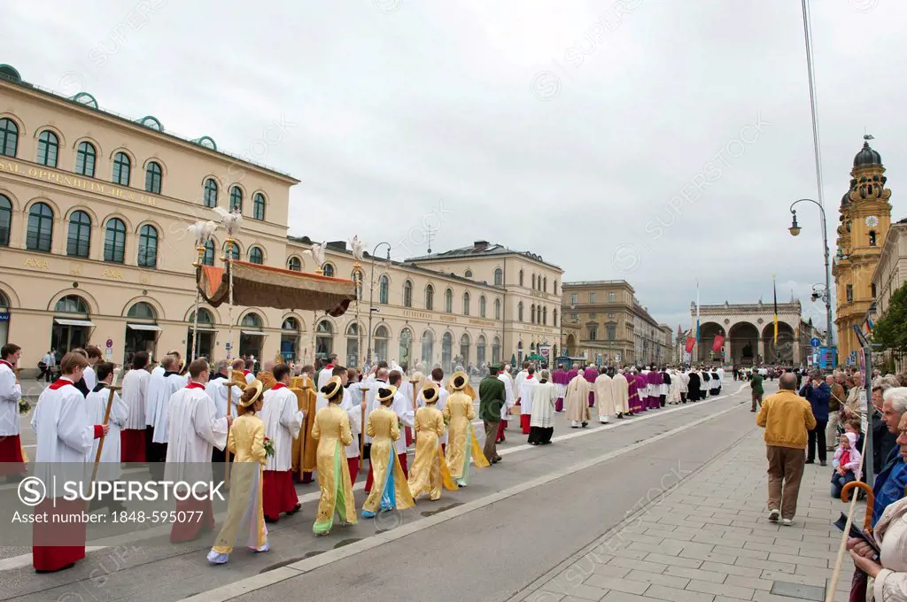 Catholic Corpus Christi procession, Archbishop Reinhard Marx carrying the monstrance with the Blessed Sacrament under a canopy, altar boys and religio...