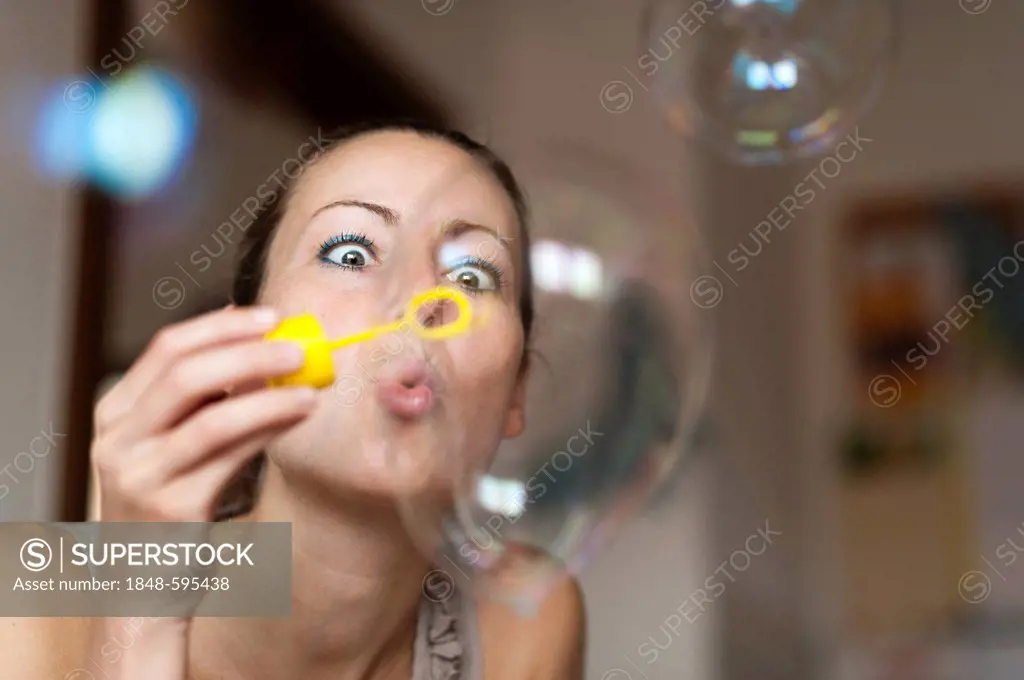 Young woman making soap bubbles