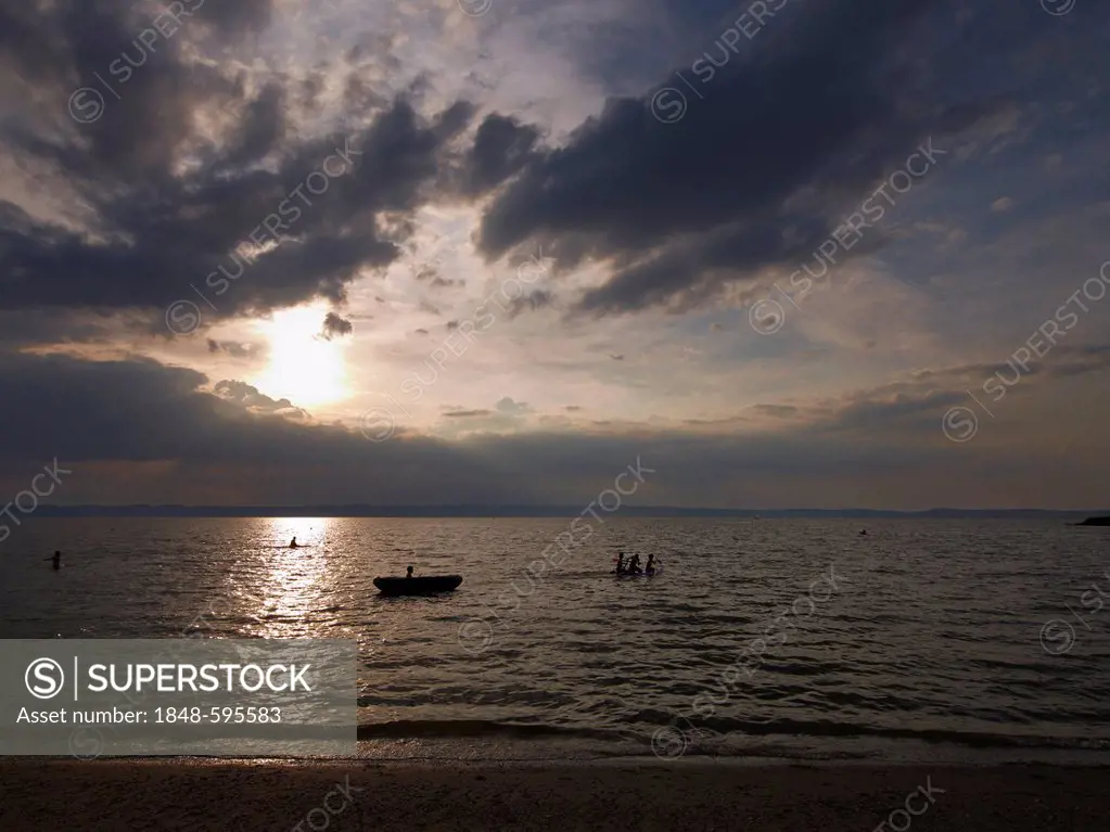 Sunset on Lake Neusiedler See with children playing in the water, Burgenland, Austria, Europe