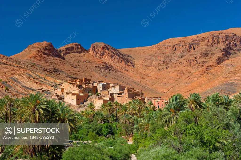 Small Berber village with palm grove in the spectacular mountain scenery of the Anti-Atlas with remarkable geological rock formations, oasis Afella Ig...