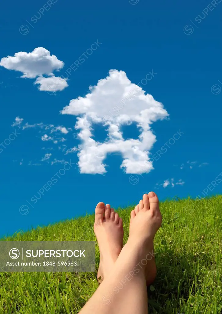 Woman lying on a meadow, detail of feet with a house-shaped cloud formation in the sky