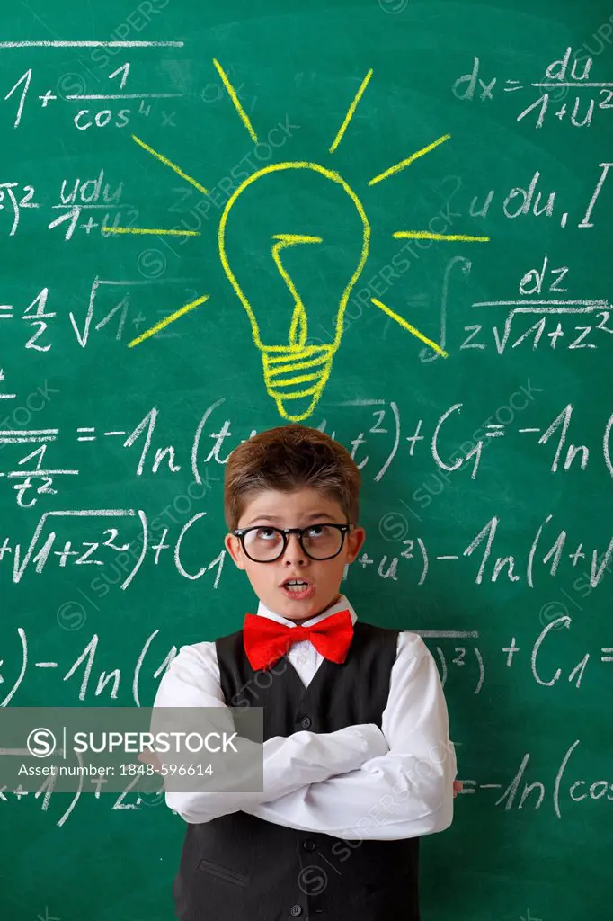 Schoolboy wearing glasses and a bow tie in front of a blackboard with math equations and a drawn light globe of inspiration