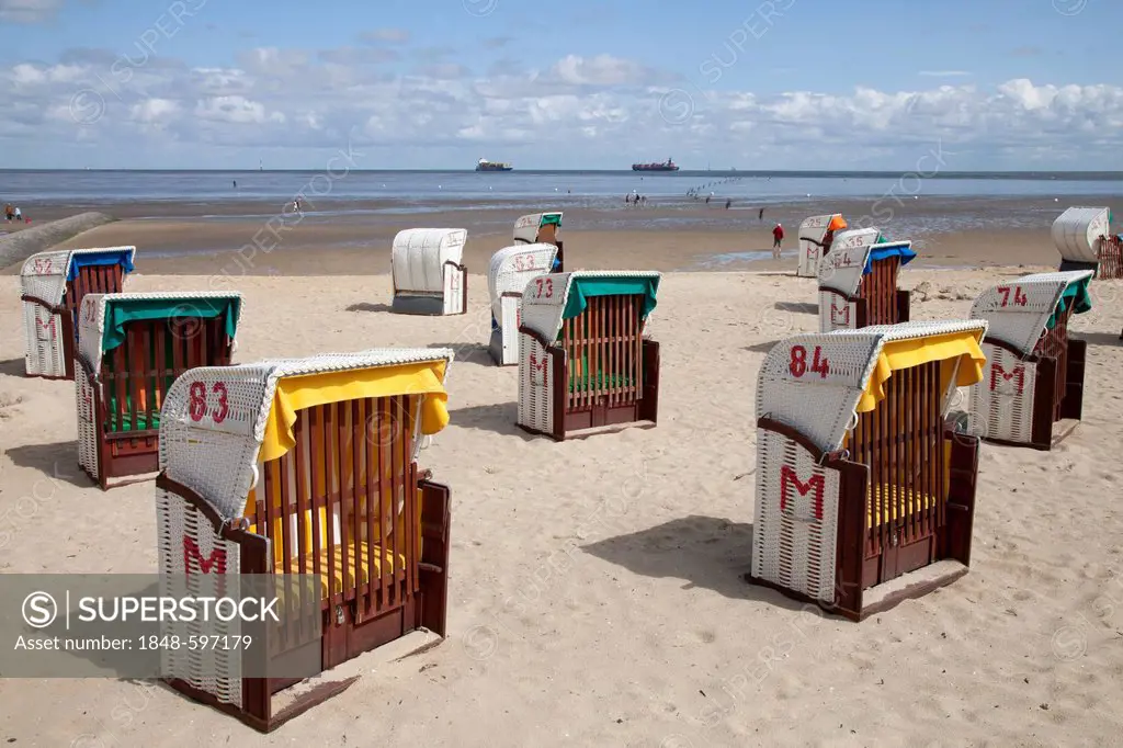 Roofed wicker beach chairs on a sandy beach, behind the Wadden sea and ships, Cuxhaven, Lower Saxony, North Sea, Germany, Europe, OeffentlicherGrund