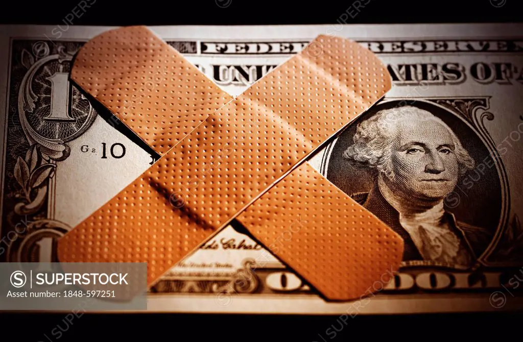 U.S. dollar with band-aid, symbolic image for the national debt of the USA
