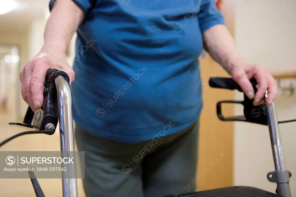 Elderly woman walking with a wheeled walker at a nursing home