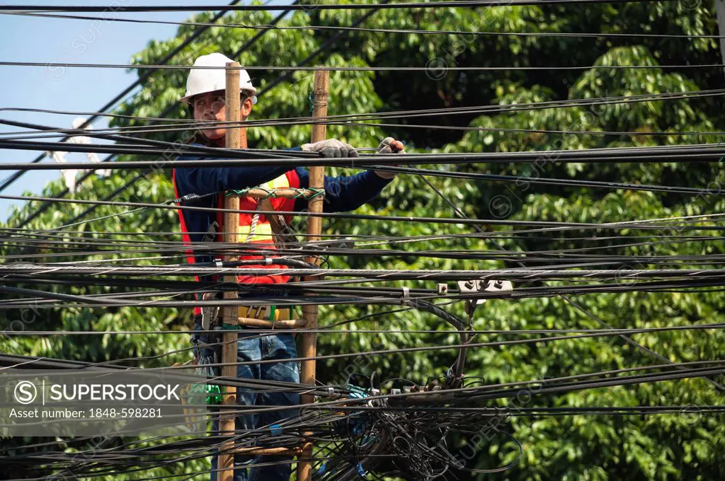 Workers on a ladder, tangled cables, Chiang Mai, Northern Thailand, Asia